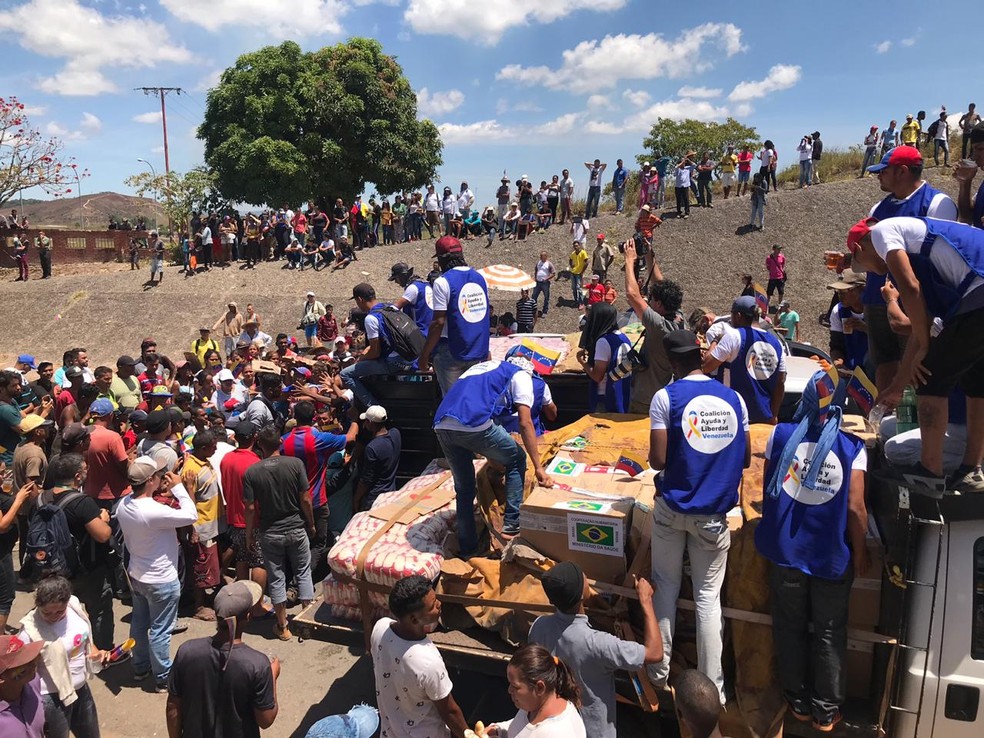 Multidão de venezuelanos cerca os dois caminhões com ajuda humanitária em Pacaraima — Foto: Alan Chaves/ G1 RR