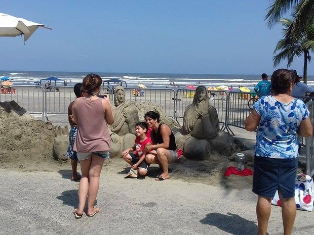 Turistas tiram foto em frente a presépio de areia montado na praia (Foto: Lelo Bianchini / Prefeitura de Peruíbe)