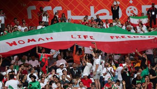 Torcedores do Irã com a bandeira com a palavra "Mulher, Vida, Liberdade", em jogo contra a Inglaterra — Foto: Fadel Senna/AFP