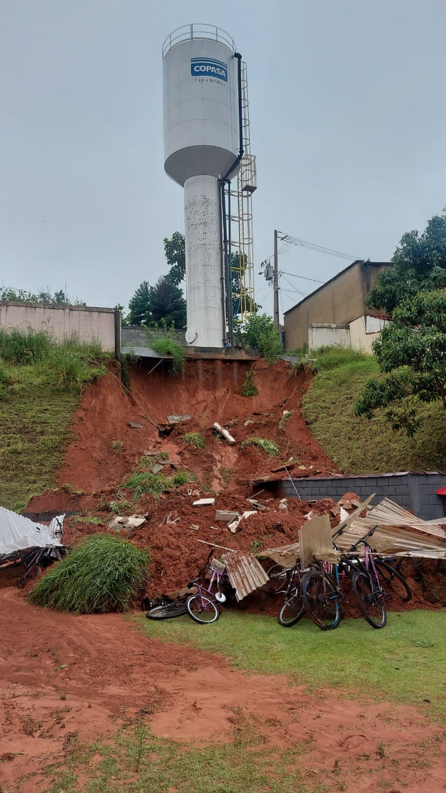 Barranco desliza, derruba muro de condomínio e moradores são retirados de casas em Pouso Alegre, MG