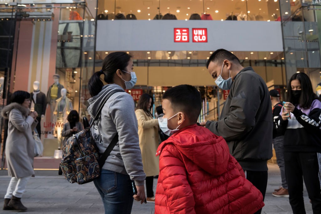 TOKYO, JAPAN - JANUARY 24: Chinese tourists wearing masks wait for a tour bus in front of a Uniqlo store in the Ginza shopping district on January 24, 2020 in Tokyo, Japan. While Japan is one of the most popular foreign travel destinations for Chinese tou (Foto: Getty Images)