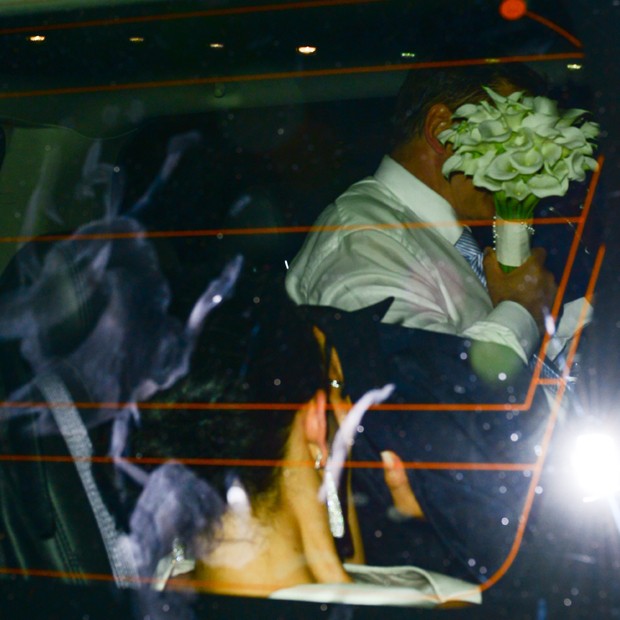 O casal ao deixar a igreja. Alec tentou se esconder com o buquê de flores (Foto: Splash News)