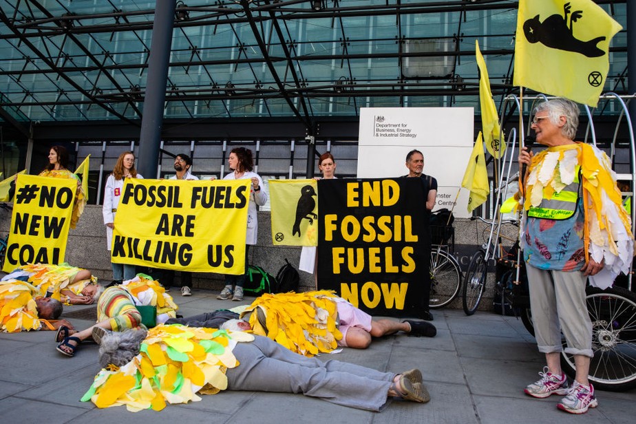 Ativistas climáticos realizam protesto contra uso de carvão à frente do Departamento de Negócios, Energia e Estratégia Industrial em Londres em julho