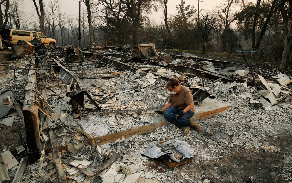 Ruínas de prédio e veículo queimados pelo incêndio Oak, que atingiu Oak Drive e Buck Mountain Road, perto de Alta Sierra, na Califórnia, no domingo (12) (Foto: Elias Funez/The Union via AP)