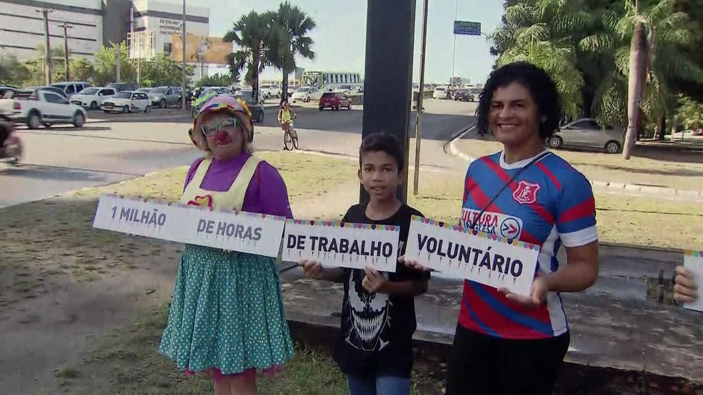 Voluntários, na Avenida Agamenon Magalhães, no Recife, celebram 1 milhão de horas trabalhadas (Foto: Robson Batista/TV Globo)