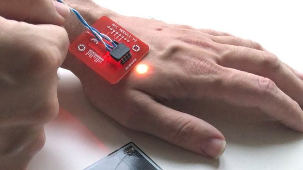 Paumen tem um chip sob a pele da mão esquerda que acende quando entra em contato próximo com uma máquina de pagamento — Foto: PATRICK PAUMEN