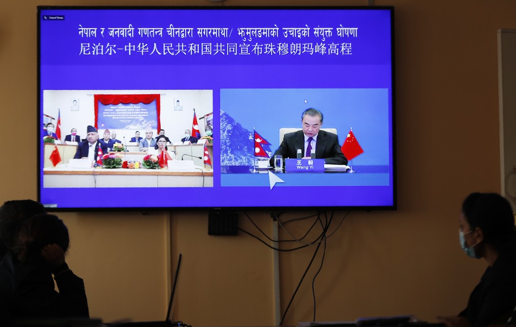 Ministros das Relações Exteriores da China e do Nepal divulgam a nova altura do Monte Everest em uma transmissão virtual — Foto: Niranjan Shrestha/AP
