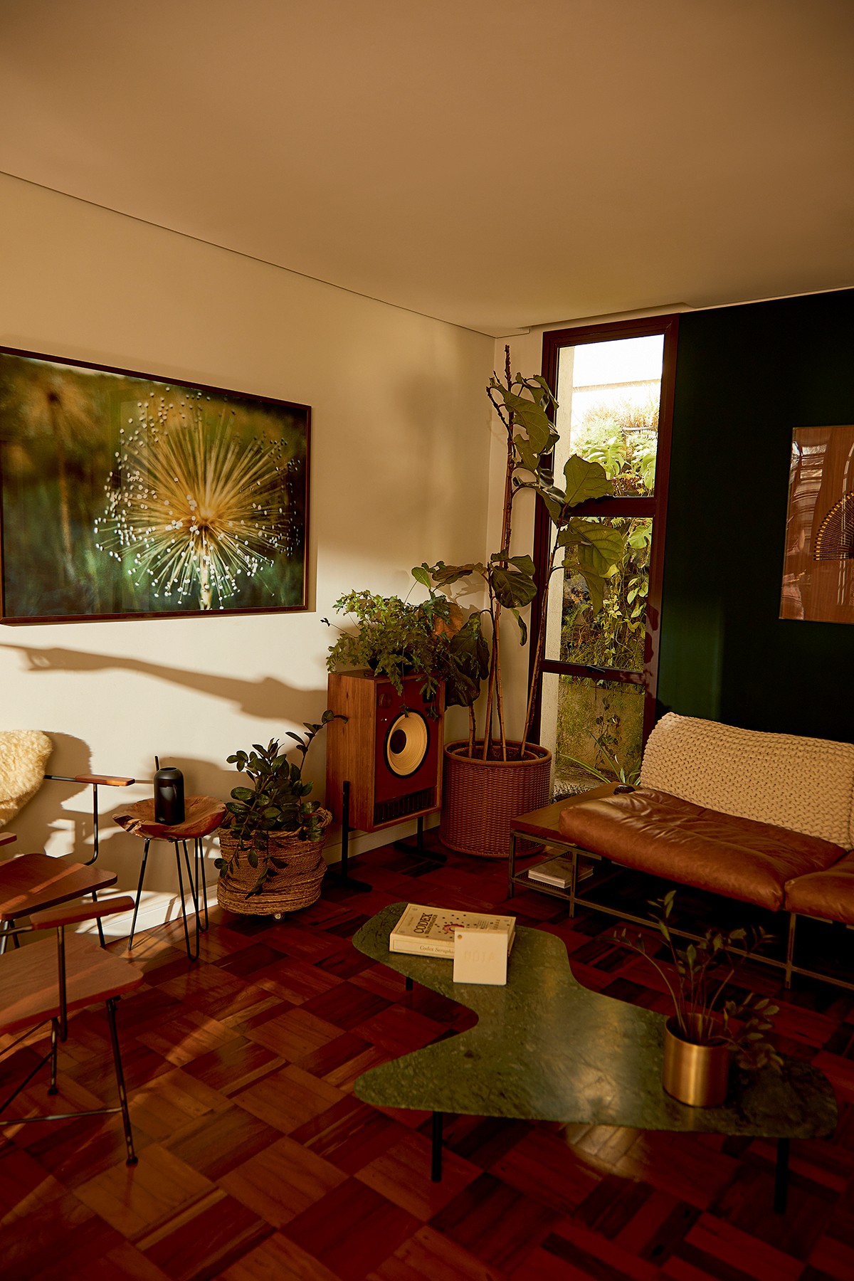 Tainá Müller - A sala de estar tem parede verde, móveis em madeira e muitas plantas (Foto: Cassia Tabatini)