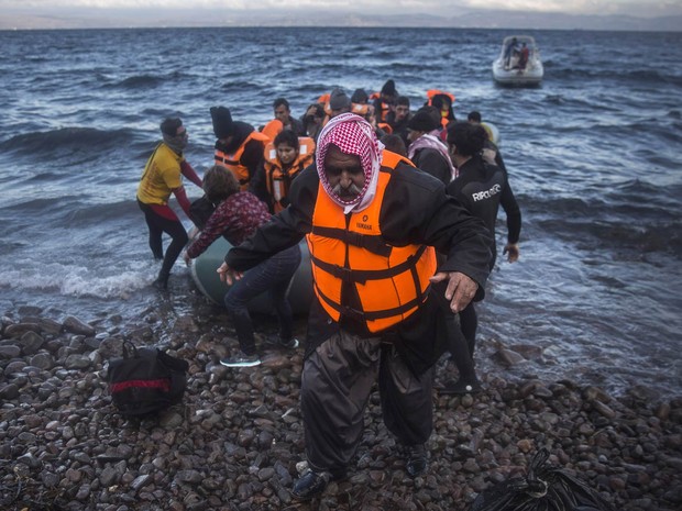 Iraquiano desembarca de um bote após cruzar o mar da costa da Turquia até uma praia de Lesbos, ilha da Grécia, com outros refugiados e migrantes. Milhares de pessoas seguem chegando à Europa, em fuga dos conflitos no oriente Médio (Foto: Santo Palacios/AP)