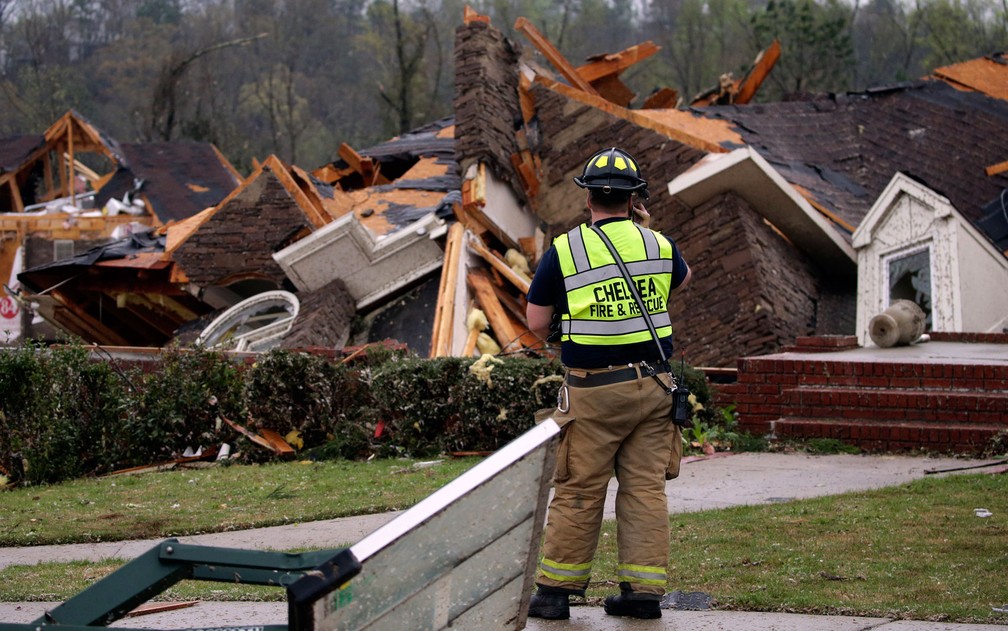 Bombeiro inspeciona escombros de casa destruída por tornado em Birmingham, Alabama, na quinta-feira (25) — Foto: AP Photo/Butch Dill