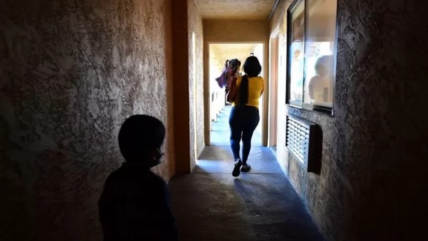 Uma imigrante venezuelana com seus dois filhos em um abrigo de caridade católico em San Diego, Califórnia. Foto tirada em 9 de novembro de 2021, após a reabertura da fronteira, que havia sido fechada devido à pandemia (Foto: FREDERIC J. BROWN/AFP VIA GETTY IMAGES via BBC)