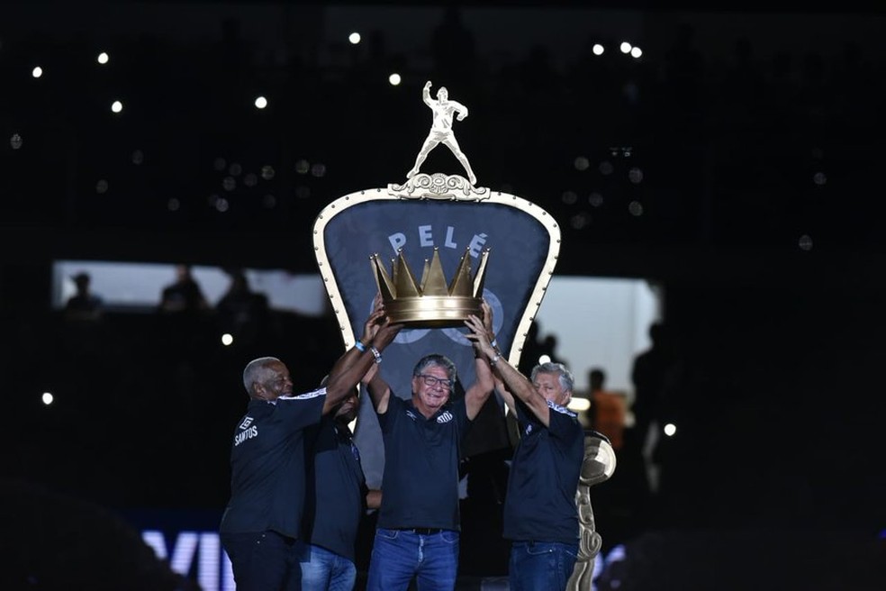 Ídolos do Santos levam coroa em homenagem a Pelé no centro do campo da Vila Belmiro — Foto: Ivan Storti / Santos FC