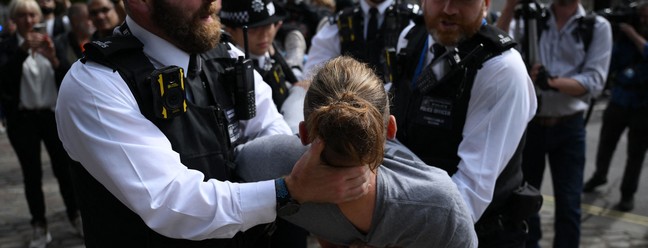 Policiais retiram manifestantes do lado de fora do Centro Rainha Elizabeth II, antes da liderança do Partido Conservador anunciar o próximo primeiro-ministro britânico, no centro de Londres — Foto: Daniel LEAL / AFP