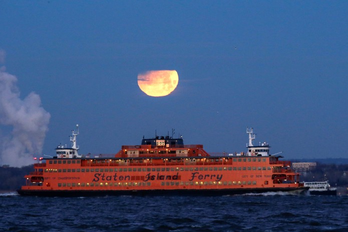 'Superlua azul de sangue', que aconteceu em janeiro deste ano Ã© vista parcialmente eclipsada sobre a balsa de Staten Island vista do Brooklyn, em Nova York, nos EUA (Foto: Eduardo MuÃ±oz/Reuters)