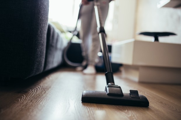 Woman cleaning the floor in living room with vacuum cleaner. cropped photo (Foto: Getty Images/iStockphoto)