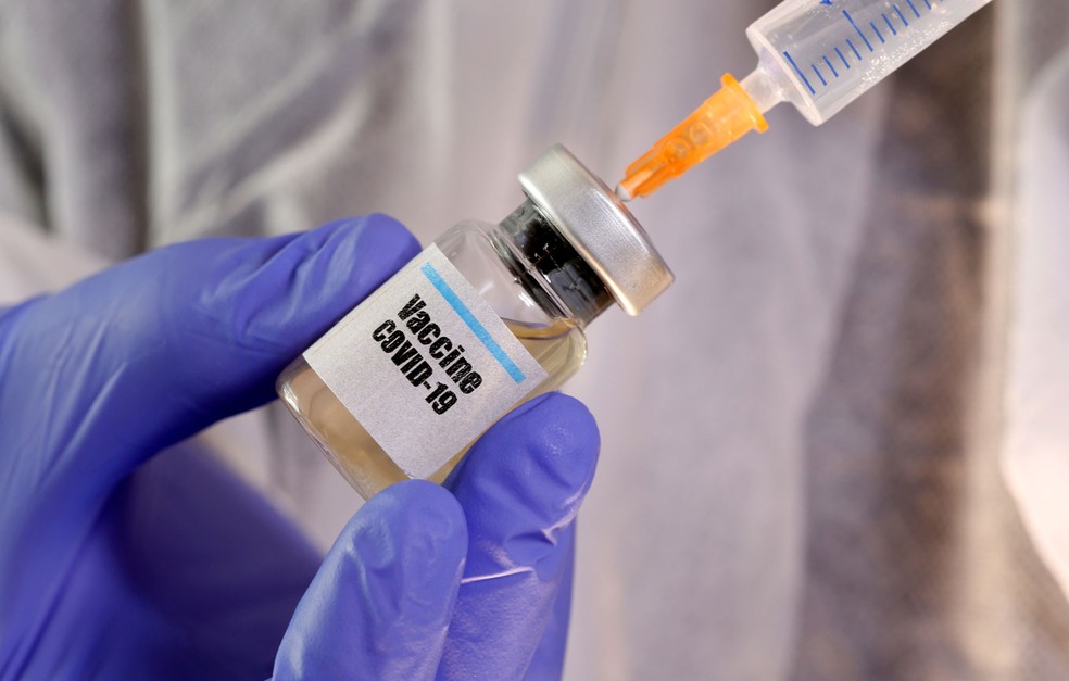Mais de 160 vacinas estão sendo desenvolvidas em todo o mundo, segundo a OMS Mulher segura frasco com a inscrição "Vacina Covid-19" em foto do dia 10 de abril de 2020 — Foto: Dado Ruvic / Reuters