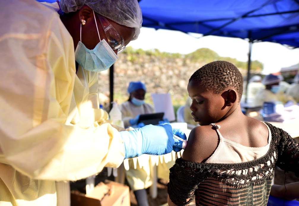 FuncionÃ¡rio de saÃºde congolÃªs vacina crianÃ§a no Centro de SaÃºde Himbi em Goma, na fronteira da RepÃºblica DemocrÃ¡tica do Congo (RDC) com Ruanda, nesta terÃ§a-feira (17) â€” Foto: Olivia Acland/Reuters