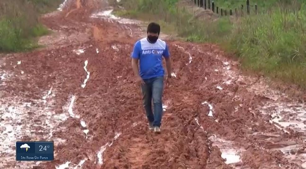 Integrante da equipe de imunização caminha pela lama — Foto: Reprodução Rede Amazônica Acre