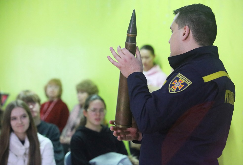 Especialista em defesa civil orienta alunos em Kharkiv — Foto: Valentyn Ogirenko/Reuters
