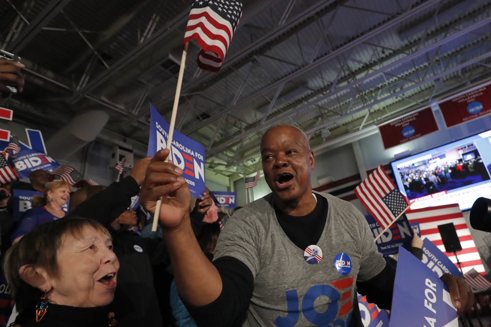 Apoiadores de Joe Biden comemoram vitória do pré-candidato nas primárias da Carolina do Sul durante comício em Columbia neste sábado (29) — Foto: Gerald Herbert/AP Photo