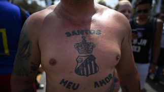 Torcedor do Santos com tatuagem do brasão do clube acompanha o cortejo de Pelé nesta terça-feira (03) — Foto: Carl de Souza / AFP