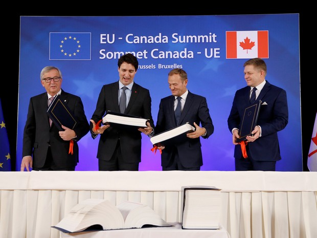 Presidente da Comissão Europeia, Jean-Claude Juncker, premiê canadense Justin Trudeau, presidente do Conselho da União Europeia, Donald Tusk, e premiê da Eslováquia, Robert Fico, durante a cerimônia de assinatura do Ceta em Bruxelas (Foto: Francois Lenoir/ Reuters)