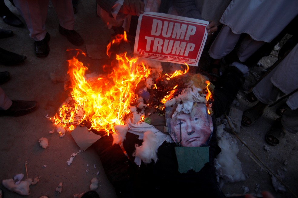 Apoiadores de partido político Jamaat-e-Islami queimam imagem de Donald Trump em 22 de dezembro, em Peshawar, no Paquistão, em protesto contra reconhecimento de Jerusalém como capital de Israel (Foto: Fayaz Aziz/Reuters)