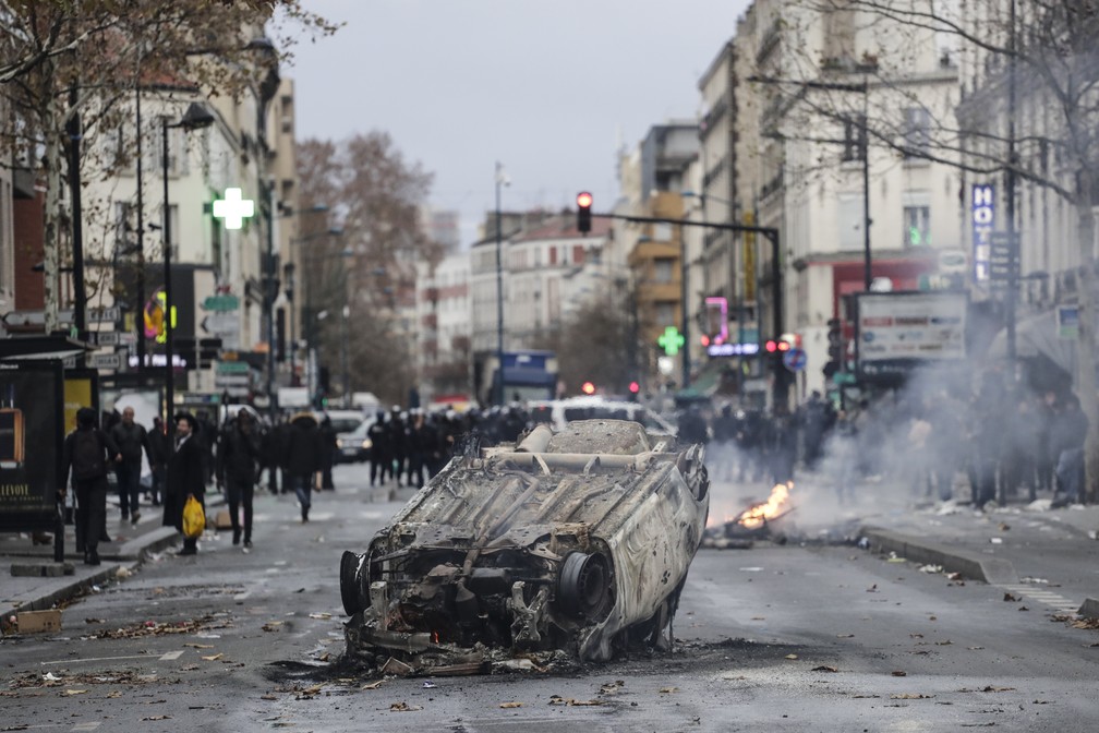 Carro é incendiado em frente à escola Jean-Pierre Timbaud, em Aubervilliers, durante protesto de estudantes contra reformas do governo na educação — Foto: Thomas Samson/ AFP