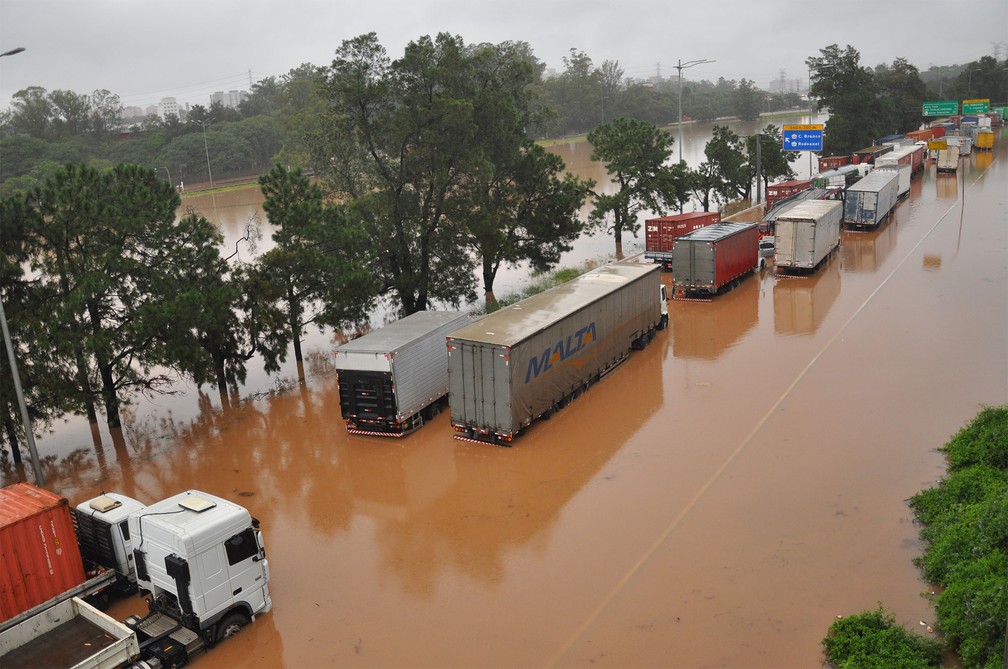 Caminhões ficaram parados em meio à água na Marginal Pinheiros, após o rio transbordar devido à chuva em São Paulo — Foto: Antônio Cícero/Photopress/Estadão Conteúdo