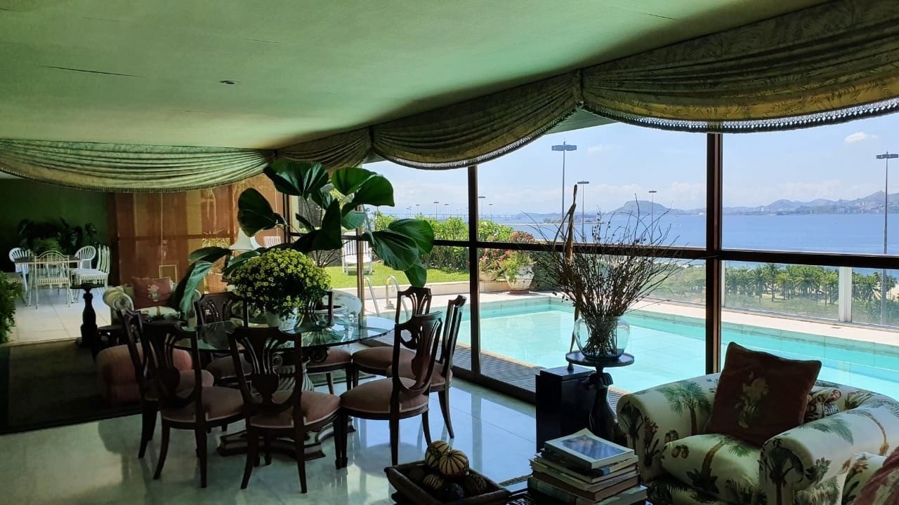 Com poltronas e mesas para relaxar, uma sala de estar em frente à piscina — Foto: Reprodução