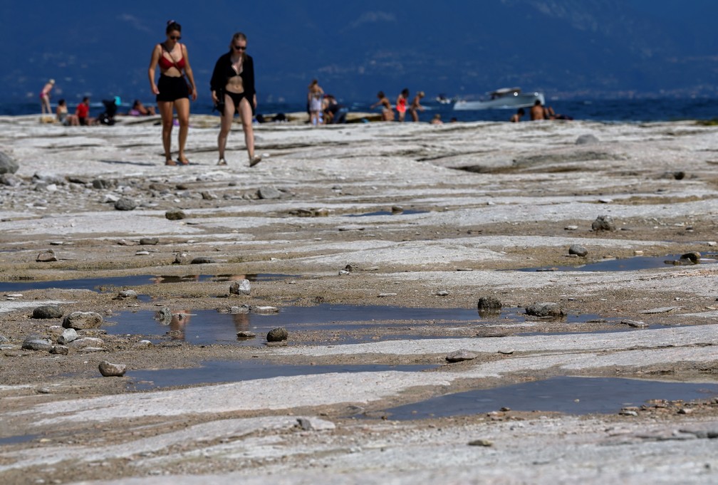 Leito rochoso do lago Garda aparece com a seca e forma uma praia em Sirmione, na Itália — Foto: REUTERS/Flavio Lo Scalzo