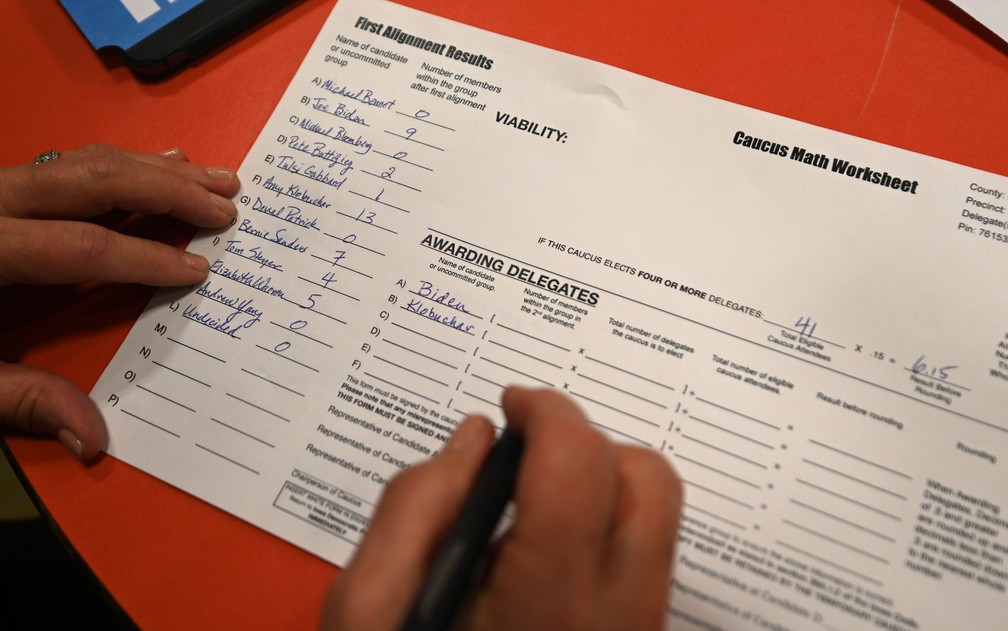 Voluntário preenche ficha em caucus do Partido Democrata em Carpenter, Iowa, na segunda-feira (3) — Foto: Steve Pope/Getty Images/AFP