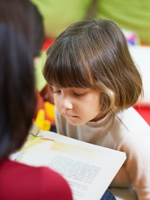 Professora lendo livro para criança (Foto: Shutterstock)