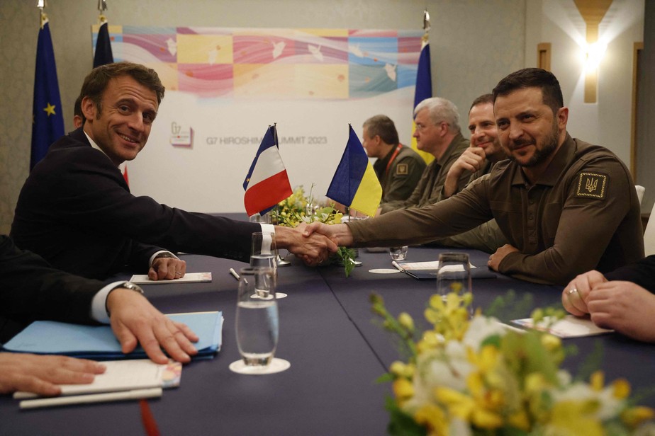 O presidente Volodymyr Zelensky (à direita) cumprimenta o presidente da França, Emmanuel Macron, durante sua reunião bilateral à margem do G7