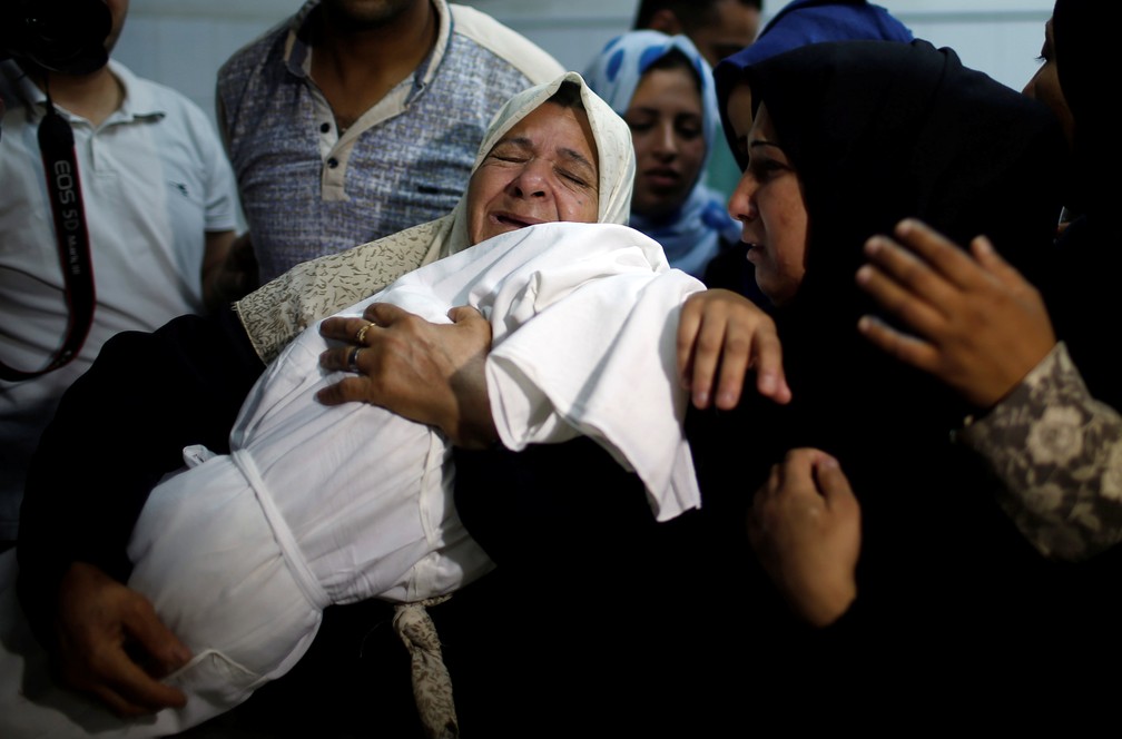 Familiares choram e carregam o corpo de bebÃª de 8 meses que morreu por inalar gÃ¡s durante protesto de segunda na Faixa de Gaza (Foto: Mohammed Salem/Reuters)