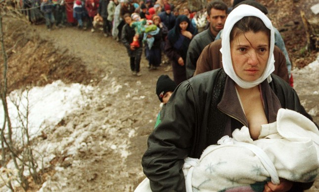 Mulher de origem albanesa amamenta bebê em fuga para Macedônia, em março de 1999