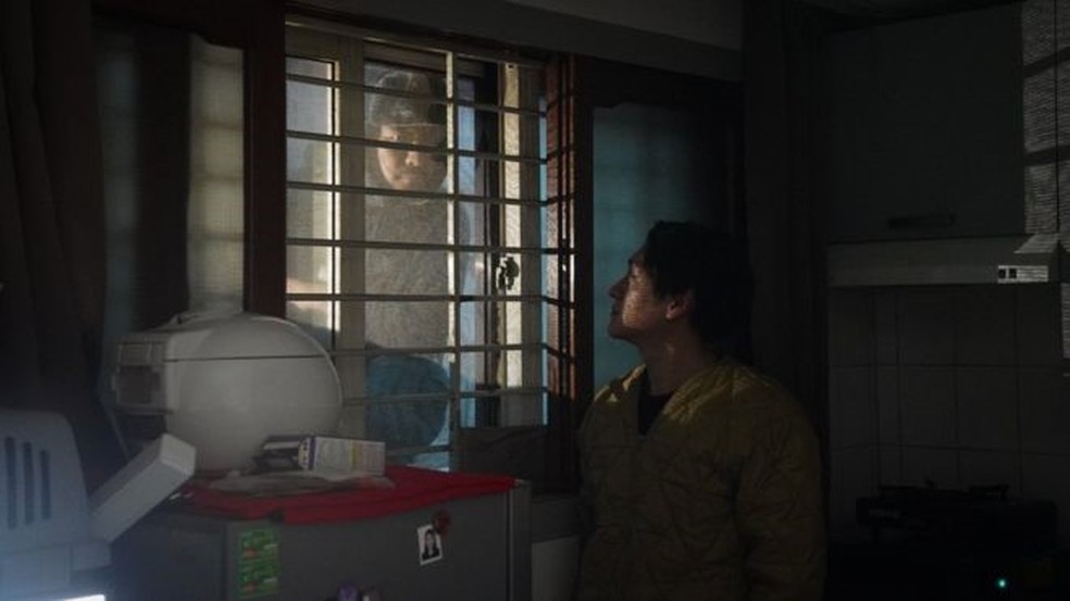 Da rua, as pessoas conseguem espiar o que acontece no apartamento de Oh kee-cheol — Foto: BBC