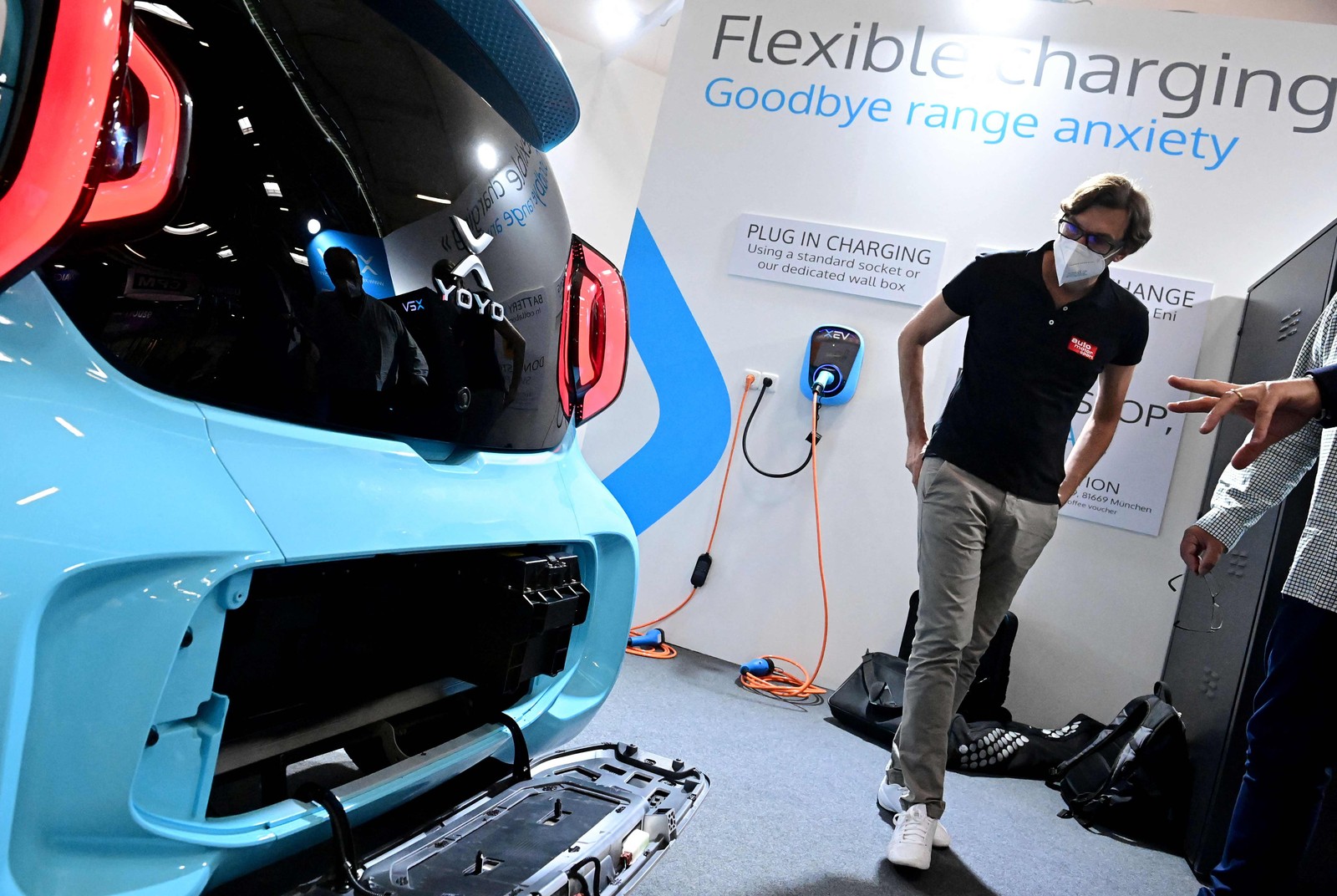 Visitante observa o sistema de troca e carregamento de bateria para um carro elétrico impresso em 3D XEV YoyoAFP