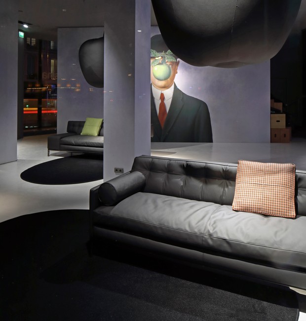 A pintura &quot;O Filho do Homem&quot; é reproduzida em uma das paredes do showroom da Cassina em Paris (Foto: Dezeen/ Reprodução)