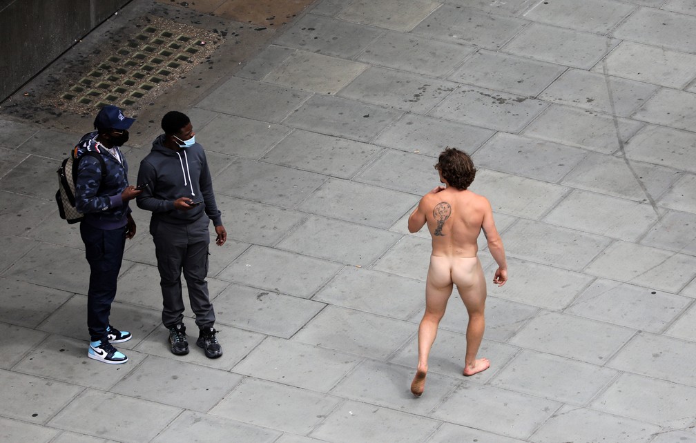 Homem caminha nu sob olhares de pessoas que caminham na Oxford Street, em Londres, nesta sexta (24) — Foto: Simon Dawson/Reuters