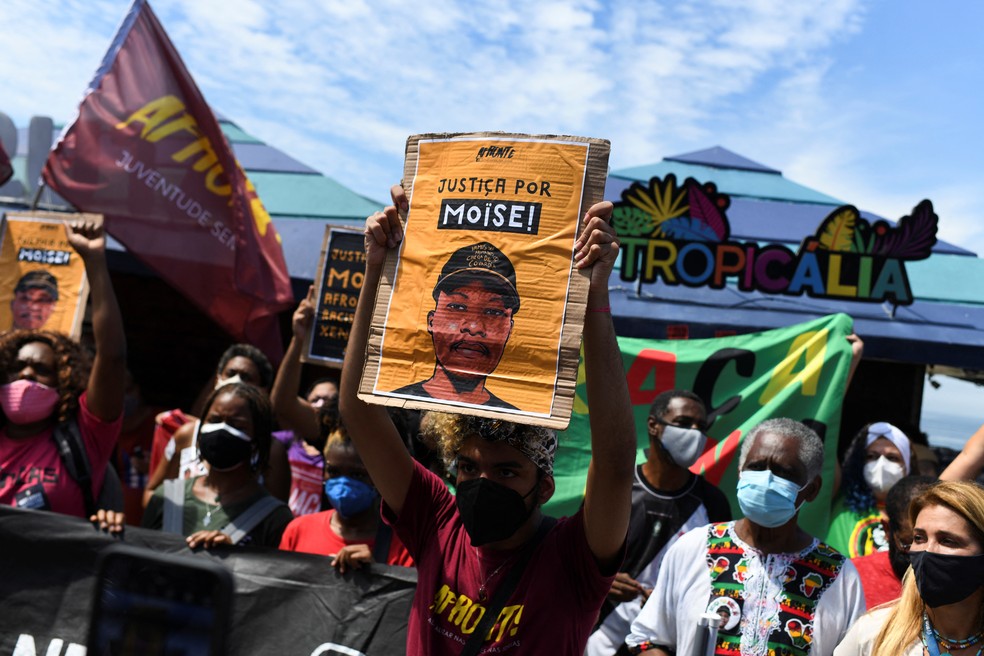 Manifestante carrega cartaz com os dizeres "justiça por Moïse" em ato no Rio em frente ao local onde o congolês foi brutalmente morto a pauladas.  — Foto: Lucas Landau/Reuters