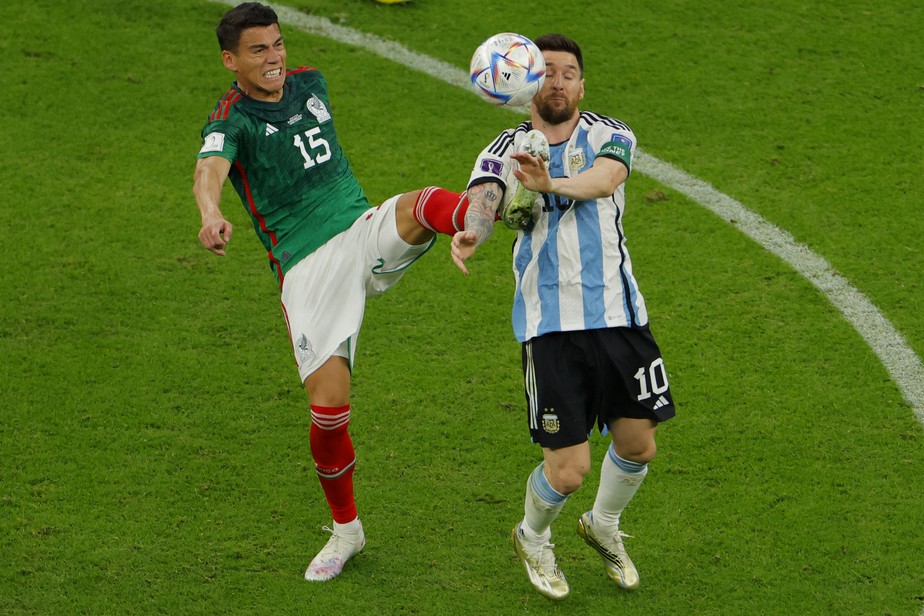 O zagueiro do México, Hector Moreno (E), luta pela bola com o atacante da Argentina, Lionel Messi (à direita), durante a Copa do Mundo de 2022 do Catar no Estádio Lusail
