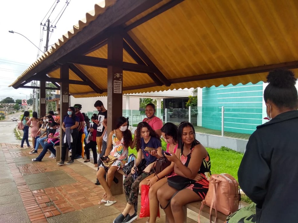Em Rio Branco, candidatos do Enem se abrigam em parada de ônibus esperando chuva passar antes da abertura dos portões  — Foto: Alcinete Gadelha/g1