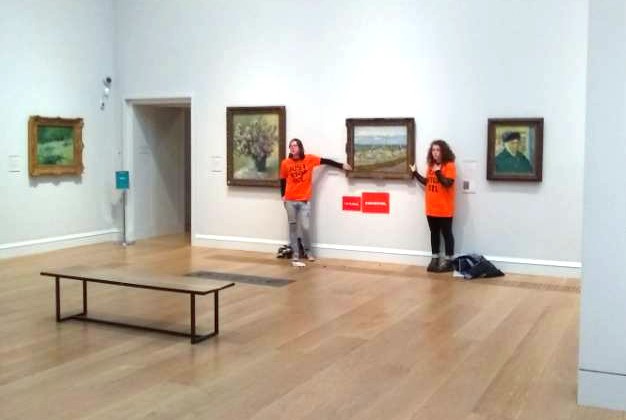 Imagem dos dois ativistas grudados na pintura de Van Gogh (Foto: Just Stop Oil )