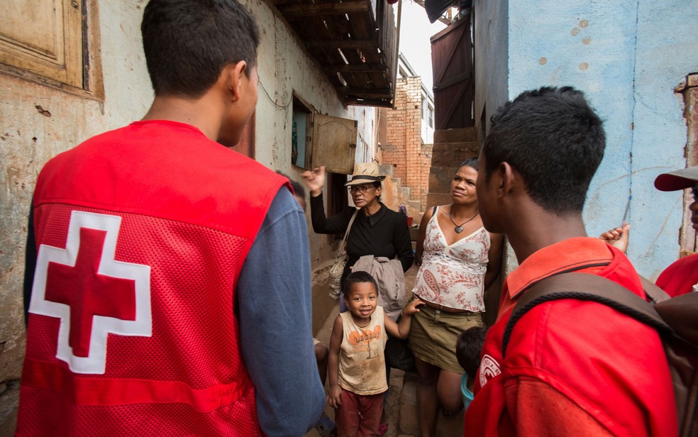 Voluntários da Cruz Vermelha orientam moradores de Antananarivo, Madagascar, sobre os casos de peste bubônica no país, na segunda-feira (16) (Foto: AP Photo/Alexander Joe)