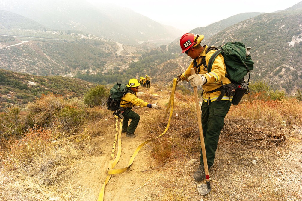 Voluntários do Arizona tentam conter um dos incêndios da Califórnia nesta sexta-feira (11) — Foto: David Crane/The Orange County Register via AP