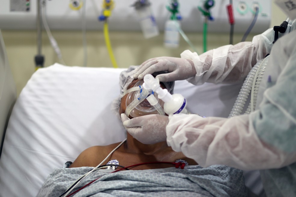 Paciente com Covid-19 tem máscara de oxigênio ajustada em UTI de hospital, em 8 de abril de 2021 — Foto: Amanda Perobelli/Reuters