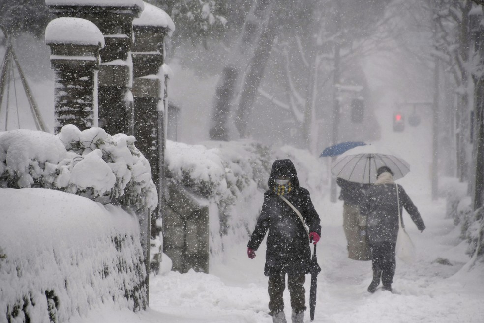 Moradores de Ishikawa, no centro do Japão, caminham sob tempestade de neve, em 23 de dezembro de 2022.  — Foto: Kyodo via Reuters  