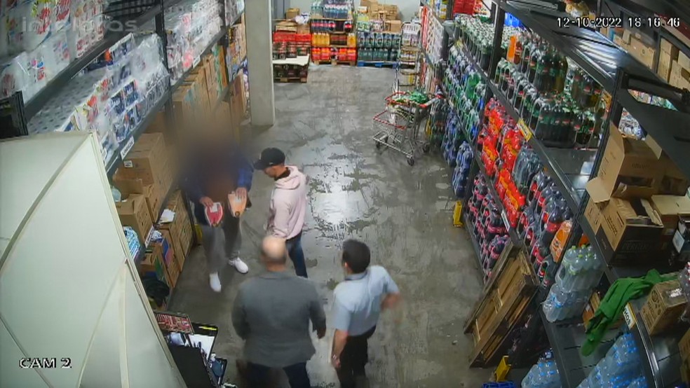Vítima das agressões tira dois pacotes de picanha debaixo da roupa e mostra aos homens suspeitos de tortura no RS. — Foto: Reprodução/RBS TV
