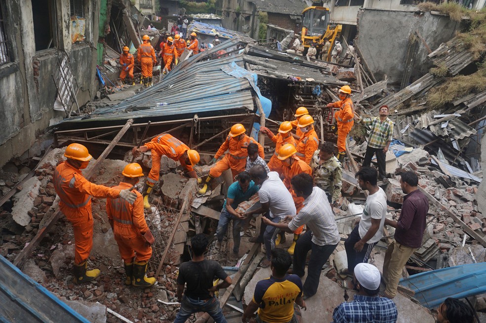 Equipes de resgate buscam por sobreviventes sob os escombros de prédio que desabou em Bhiwandi, no subúrbio de Mumbai, na Índia, nesta segunda-feira (21)  — Foto: Praful Gangurde/AP 